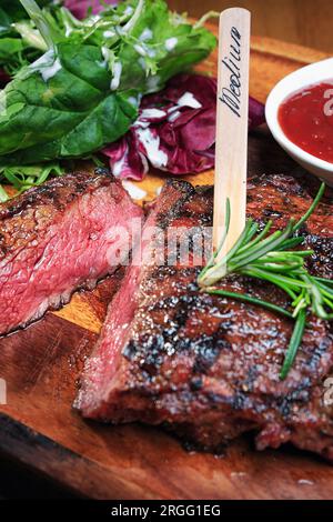 Steak de viande sur la planche de bois. Gros plan Banque D'Images