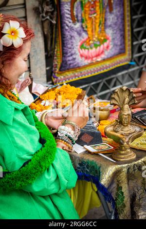 Un diseur de fortune thaïlandais est assis avec une jeune fille thaïlandaise sur Sala Daeng Rd. Bangkok Thaïlande. Banque D'Images