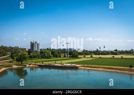 Étang dans la ville de Mannheim avec téléphérique reliant les parcs pendant l'horticulture fédérale et le salon du jardin (Bundesgartenschau BUGA), Allemagne Banque D'Images