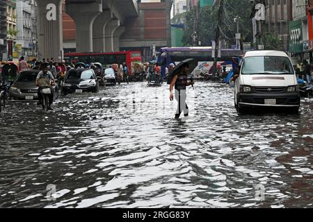 Dhaka, Bangladesh. 09 août 2023. Des véhicules essaient de conduire et les citoyens marchent dans les rues d'engorgement à Dhaka, au Bangladesh, le 9 août 2023. Les fortes pluies de mousson ont provoqué une engorgement extrême des eaux dans la plupart des zones de la ville de Dhaka, au Bangladesh. Les routes étaient submergées rendant les déplacements lents et dangereux. Crédit : Mamunur Rashid/Alamy Live News Banque D'Images