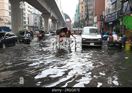 Dhaka, Bangladesh. 09 août 2023. Des véhicules essaient de conduire et les citoyens marchent dans les rues d'engorgement à Dhaka, au Bangladesh, le 9 août 2023. Les fortes pluies de mousson ont provoqué une engorgement extrême des eaux dans la plupart des zones de la ville de Dhaka, au Bangladesh. Les routes étaient submergées rendant les déplacements lents et dangereux. Crédit : Mamunur Rashid/Alamy Live News Banque D'Images