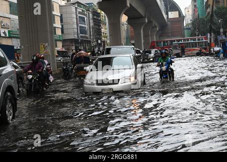 Dhaka, Bangladesh. 09 août 2023. Des véhicules essaient de conduire et les citoyens marchent dans les rues d'engorgement à Dhaka, au Bangladesh, le 9 août 2023. Les fortes pluies de mousson ont provoqué une engorgement extrême des eaux dans la plupart des zones de la ville de Dhaka, au Bangladesh. Les routes étaient submergées rendant les déplacements lents et dangereux. Crédit : Mamunur Rashid/Alamy Live News Banque D'Images