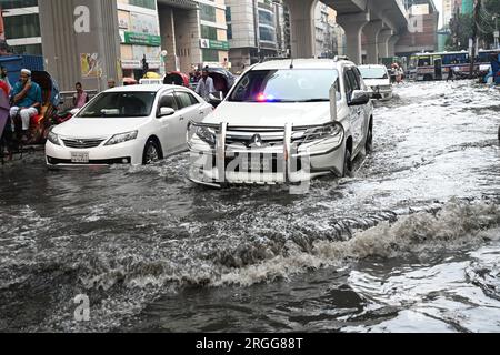 Dhaka, Bangladesh. 09 août 2023. Des véhicules essaient de conduire et les citoyens marchent dans les rues d'engorgement à Dhaka, au Bangladesh, le 9 août 2023. Les fortes pluies de mousson ont provoqué une engorgement extrême des eaux dans la plupart des zones de la ville de Dhaka, au Bangladesh. Les routes étaient submergées rendant les déplacements lents et dangereux. Crédit : Mamunur Rashid/Alamy Live News Banque D'Images