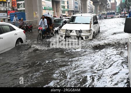 Dhaka, Bangladesh. 09 août 2023. Des véhicules essaient de conduire et les citoyens marchent dans les rues d'engorgement à Dhaka, au Bangladesh, le 9 août 2023. Les fortes pluies de mousson ont provoqué une engorgement extrême des eaux dans la plupart des zones de la ville de Dhaka, au Bangladesh. Les routes étaient submergées rendant les déplacements lents et dangereux. Crédit : Mamunur Rashid/Alamy Live News Banque D'Images