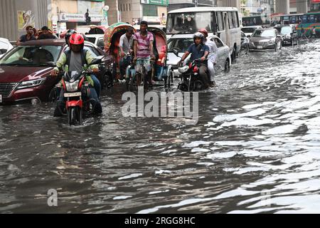 Dhaka, Bangladesh. 09 août 2023. Des véhicules essaient de conduire et les citoyens marchent dans les rues d'engorgement à Dhaka, au Bangladesh, le 9 août 2023. Les fortes pluies de mousson ont provoqué une engorgement extrême des eaux dans la plupart des zones de la ville de Dhaka, au Bangladesh. Les routes étaient submergées rendant les déplacements lents et dangereux. Crédit : Mamunur Rashid/Alamy Live News Banque D'Images