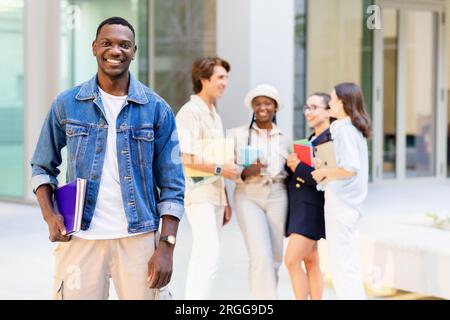 Beau gars noir posant sur un groupe multiracial d'étudiants Banque D'Images
