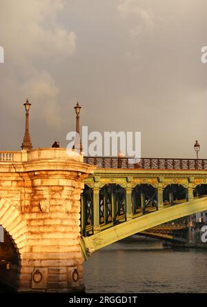 Le métal vert du Pont notre Dame qui relie le Rvier Seine à Paris, brille en début de soirée en lumière dorée après de fortes pluies en mai Banque D'Images