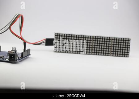 Projet d'électronique maison qui montre la carte de microcontrôleur connectée à une carte d'affichage à matrice de points LED à l'aide de fils volants Banque D'Images
