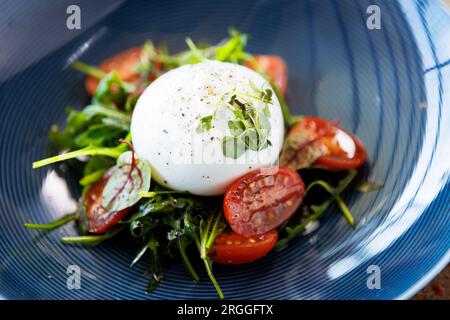 Burrata avec confiture de paprika-truffe et salade de tomates cerises-grappes. Délicieux gros plan de cuisine traditionnelle italienne saine servi pour le déjeuner dans le moderne Banque D'Images