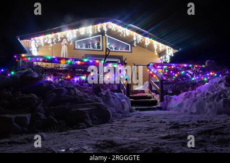 Neigé dans la maison de vacances avec des lumières décoratives de noël Banque D'Images