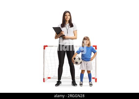 Enseignante PE féminine debout devant un mini but avec une petite fille isolée sur fond blanc Banque D'Images