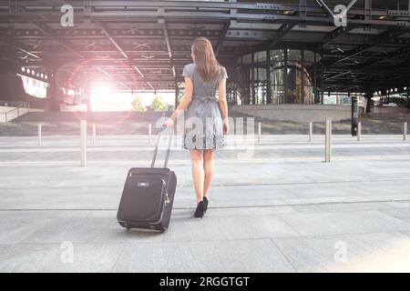 Jeune femme en robe grise avec une assurance à roues Banque D'Images