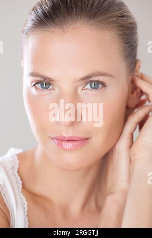Portrait rapproché d'une femme souriante avec une expression sereine. Banque D'Images