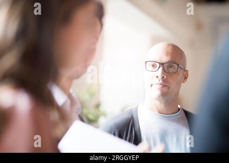 Businessman avec des lunettes à l'écoute de in office Banque D'Images