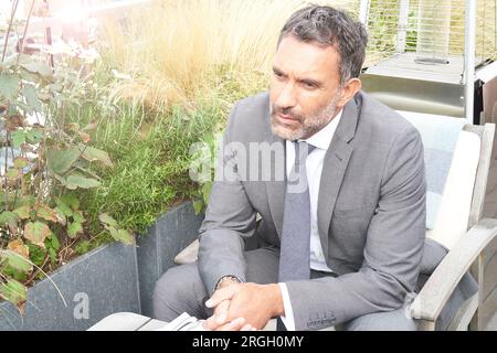 Businessman sitting in armchair at restaurant Banque D'Images