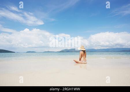 Jeune femme assise sur la plage à Ko Samui, Thaïlande Banque D'Images