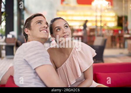 Young couple sitting on sofa Banque D'Images