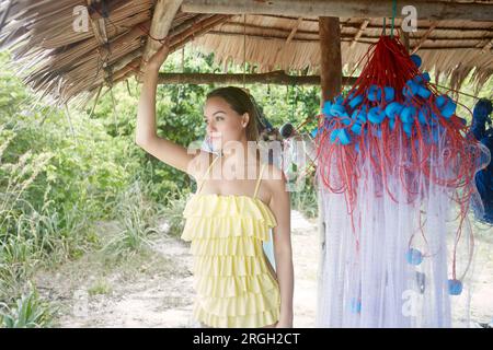 Jeune femme en cabane de plage avec filet de pêche Banque D'Images