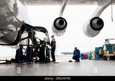 Des hommes travaillant sur la roue d'avion Banque D'Images