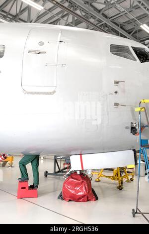Jambes de travailleur sous avion Banque D'Images