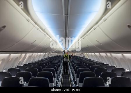 Homme aspirant l'intérieur de l'avion Banque D'Images