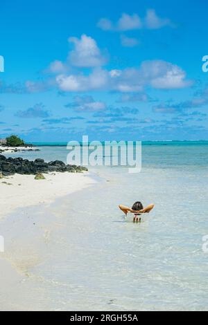 Femme assise sur une chaise dans la mer Banque D'Images