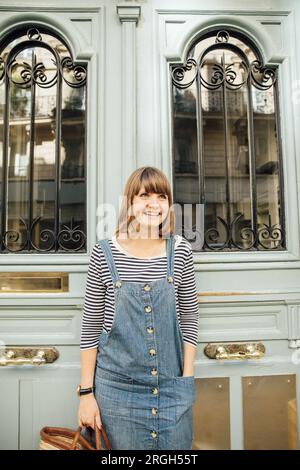 Jeune femme souriante par porte bleue Banque D'Images