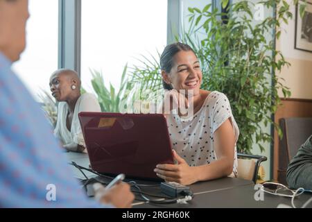 Jeune femme avec un ordinateur portable au cours de réunion Banque D'Images