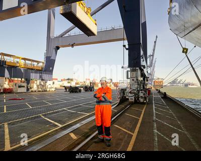 Docker en combinaison orange sur le port de Felixstowe, England Banque D'Images