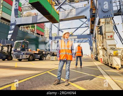 Docker en gilet réfléchissant sous crane Banque D'Images