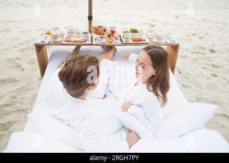 Young couple wearing peignoirs au beach de Ko Samui, Thaïlande Banque D'Images