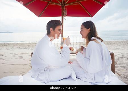 Young couple wearing peignoirs au beach de Ko Samui, Thaïlande Banque D'Images