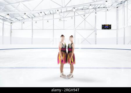 Porter des robes colorées patinage synchronisé à la patinoire de glace Banque D'Images
