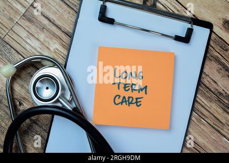 Concept de soins de longue durée écrire sur des notes adhésives avec stéthoscope isolé sur la table en bois. Banque D'Images