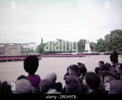 Circa 1950, Buckingham Palace, Royaume-Uni. Le Trooping of the Colors est un événement annuel qui a débuté en 1700. Plus de 1400 soldats défilants, 200 chevaux et 400 musiciens se réunissent chaque année au mois de juin pour une grande démonstration de précision militaire, d'équitation et de fanfare pour marquer l'anniversaire officiel du souverain. Les rues sont bordées de foules brandissant des drapeaux tandis que le défilé se déplace de Buckingham Palace et le long du Mall à Horse Guard Parade, aux côtés des membres de la famille royale à cheval et en calèche. La cérémonie se termine par un survol de la RAF observé par des membres de la famille royale de Buc Banque D'Images