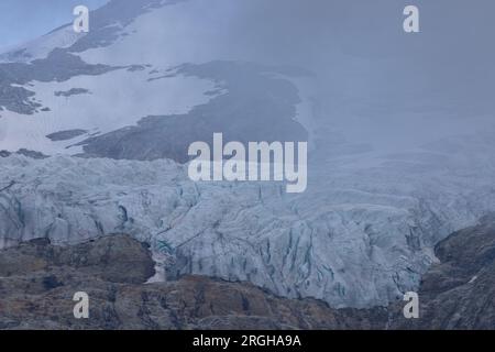 Vue panoramique sur le grand glacier Titlis en Suisse avec ciel bleu, nuages blancs, montagnes enneigées. Banque D'Images