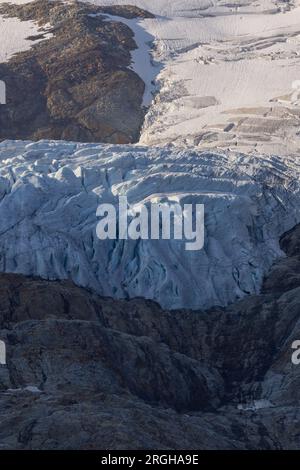 Vue panoramique sur le grand glacier Titlis en Suisse avec ciel bleu, nuages blancs, montagnes enneigées. Banque D'Images