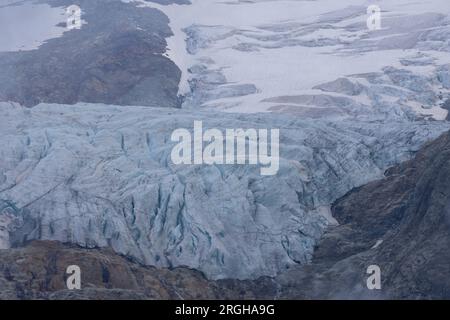 Vue panoramique sur le grand glacier Titlis en Suisse avec ciel bleu, nuages blancs, montagnes enneigées. Banque D'Images