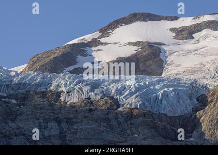 Vue panoramique sur le grand glacier Titlis en Suisse avec ciel bleu, nuages blancs, montagnes enneigées. Banque D'Images