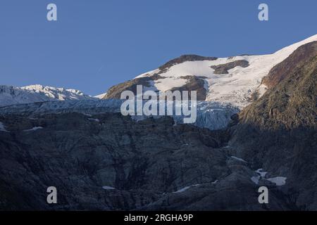 Vue panoramique sur le grand glacier Titlis en Suisse avec ciel bleu, nuages blancs, montagnes enneigées. Banque D'Images