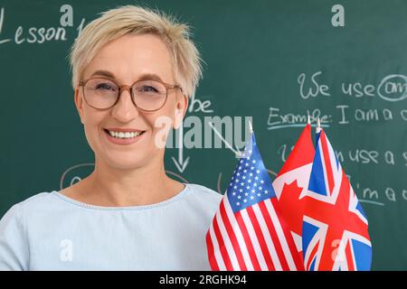 Professeur d'anglais féminin avec différents drapeaux dans la salle de classe, closeup Banque D'Images