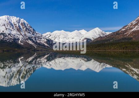 Réflexions de montagnes couvertes de neige de Kenai Lake sur la péninsule de Kenai, près de Seward, Alaska. Banque D'Images