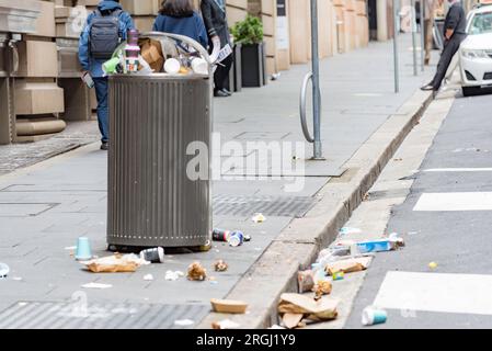 Tasses à café et conteneurs de nourriture dans la rue et les déchets débordant d'une poubelle trop pleine dans le centre de Sydney, Nouvelle-Galles du Sud, Australie Banque D'Images