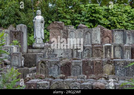 Statues en pierre d'Ojizou san, protecteur des enfants et protecteur des voyageurs, et centaines de petites tombes, Kanazawa Japon. Banque D'Images