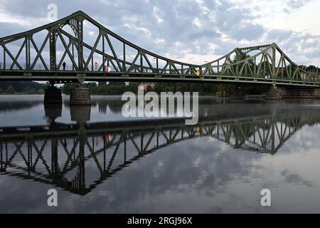 Potsdam, Allemagne. 10 août 2023. Un homme prend une photo du pont Glienicke traversant la rivière Havel. Le pont à la frontière de la ville entre Potsdam et Berlin est un symbole pour surmonter la division entre l'est et l'Ouest. De nombreux événements commémorent également la construction du mur et de la division allemande cette année le 13 août. Crédit : Soeren Stache/dpa/Alamy Live News Banque D'Images