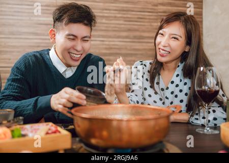 Heureux couple dînant dans le restaurant Hotpots Banque D'Images