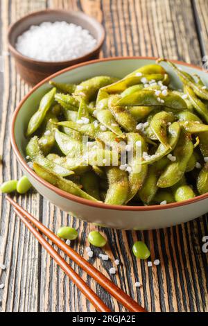 Haricots de soja épicés grillés Edamame avec du sel de mer closeup sur l'assiette sur la table. Vertical Banque D'Images