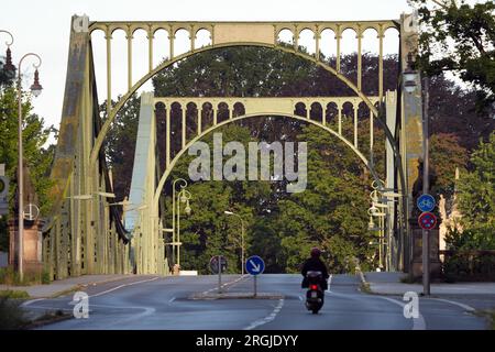 Potsdam, Allemagne. 10 août 2023. Un homme monte son cyclomoteur sur le pont de Glienicke. Le pont à la frontière de la ville entre Potsdam et Berlin est un symbole pour surmonter la division entre l'est et l'Ouest. Cette année, de nombreux événements du 13 août commémorent la construction du mur et la division de l'Allemagne. Crédit : Soeren Stache/dpa/Alamy Live News Banque D'Images