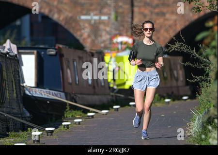 Brindley place Birmingham, 10 août 2023 : les gens étaient dehors pour faire de l'exercice à Birmingham profitant du soleil chaud du matin avant que les températures ne soient prévues pour atteindre 26 degrés dans la ville des Midlands. Un chien appelé Dash a même pu s'asseoir sous un parasol sur son bateau de canal en mangeant une mastication. Crédit : Arrêter Press Media/Alamy Live News Banque D'Images