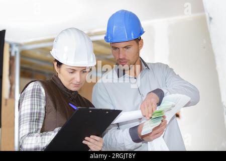 architecte et constructeur avec presse-papiers dans le chantier de construction Banque D'Images